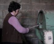 A D.Fátima Gomes, de Mirandela, mostra a sua máquina para fiar onde fia a maior parte da lã que utiliza para tecer os seus tapetes. Trata-se de um aparelho semi-industrial, provavelmente das primeiras décadas do séc.XX, que aumenta rendimento de produção enquanto permite a especificidade do trabalho artesanal executado pela artesã. / Fátima Gomes, from Mirandela, shows us her electric spinning machine, where she spins most of the wool she uses to weave her carpets. It&#39;s a semi-industria